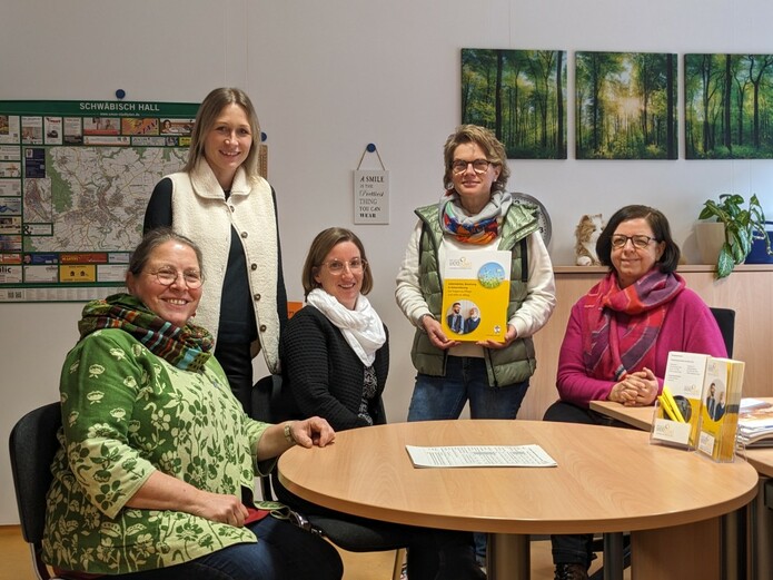 Die Mitarbeiterinnen des Pflegestützpunkts im Landkreis Schwäbisch Hall sitzen und stehen um den Tisch im Beratungsraum herum. Von links nach rechts: Silvia Haase, Carina Kohler, Dorothee Schumm und Regine Hammer.